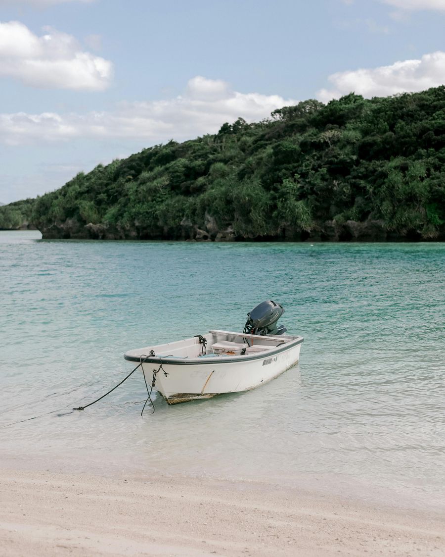 A quiet tropical beach with a small boat moored offshore